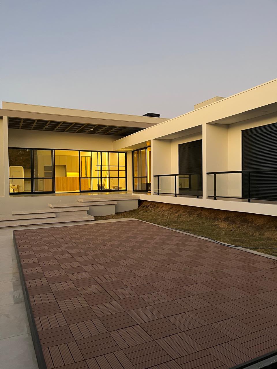 Fachada contemporânea com deck modular ao entardecer
